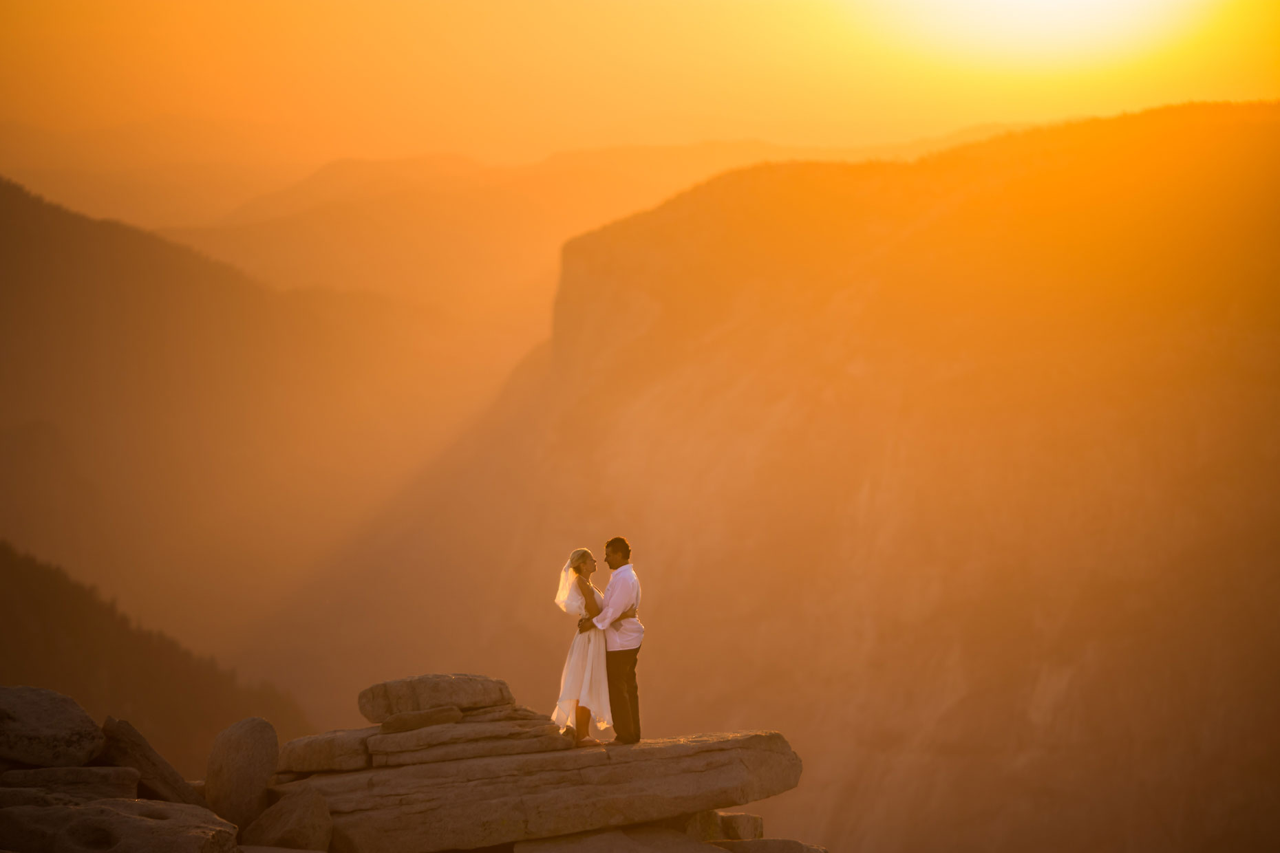 Bride and groom romantic portrait on Half Dome in Yosemite.