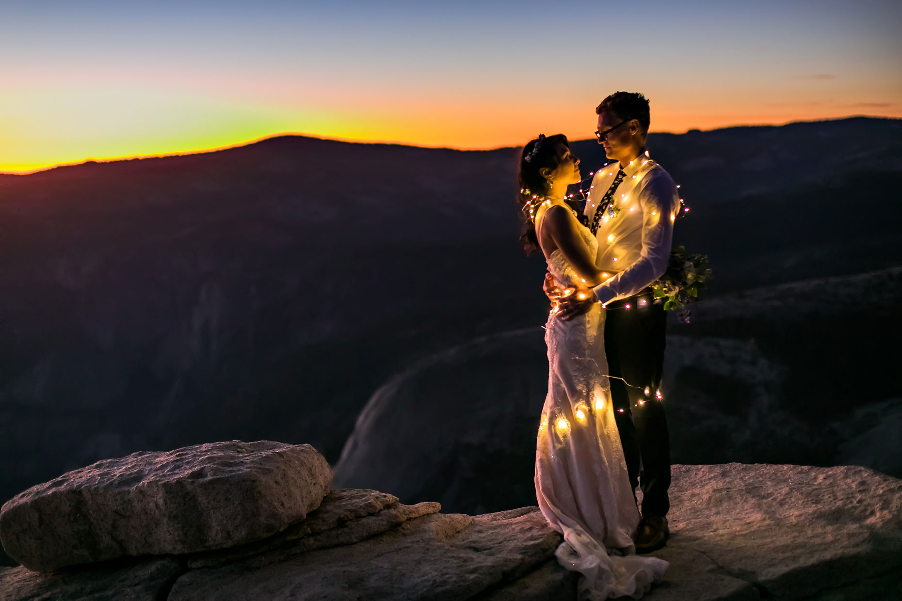 Wedding couple with fairly lights being romantic in Yosemite.